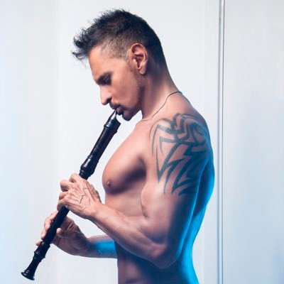 El flautista Horacio Franco en un retrato con el dorso desnudo mientras toca la flauta