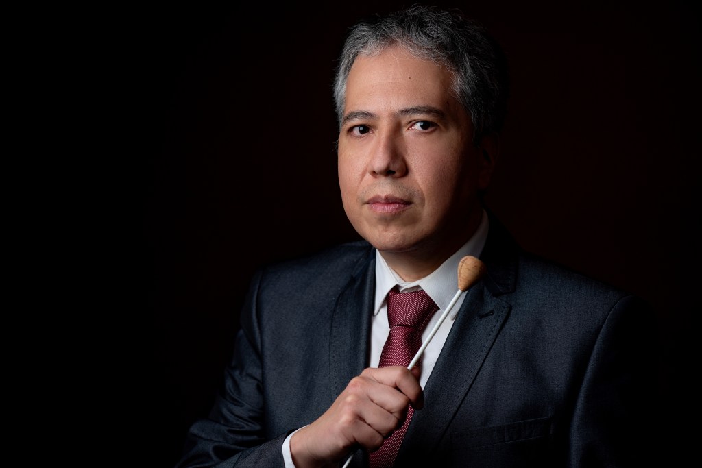 El director de orquesta Ludwig Carrasco sostiene una batuta